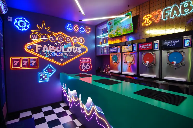 Balcão do Fabulous com letreiros de neon e piso xadrez