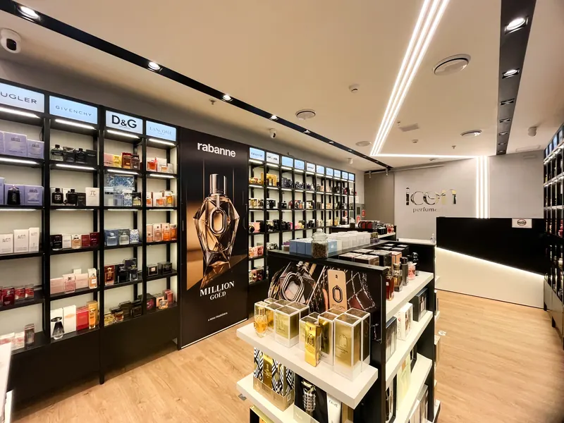 Loja Icon com prateleiras pretas iluminadas e expositores centrais de perfumes