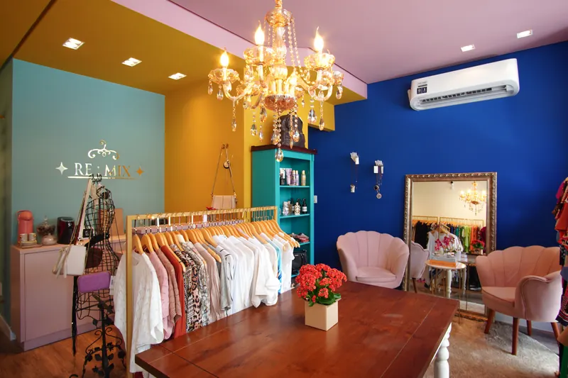Loja Remix com paredes coloridas, lustre e arara de roupas